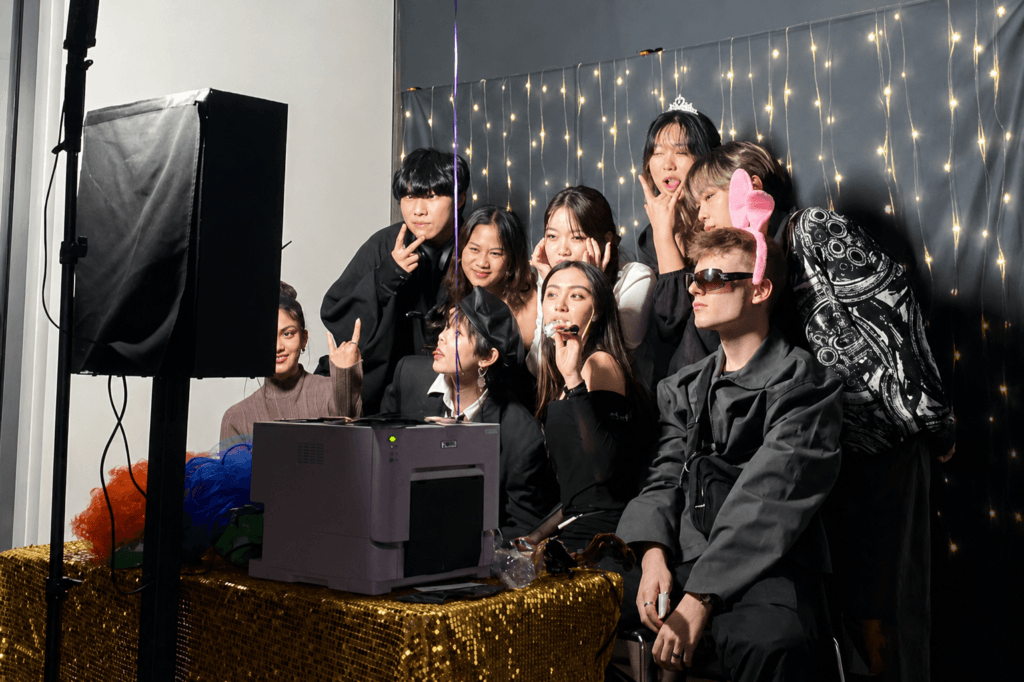 Party Photobooth dengan backdrop lampu hias, printer instan, dan properti kostum di acara pesta